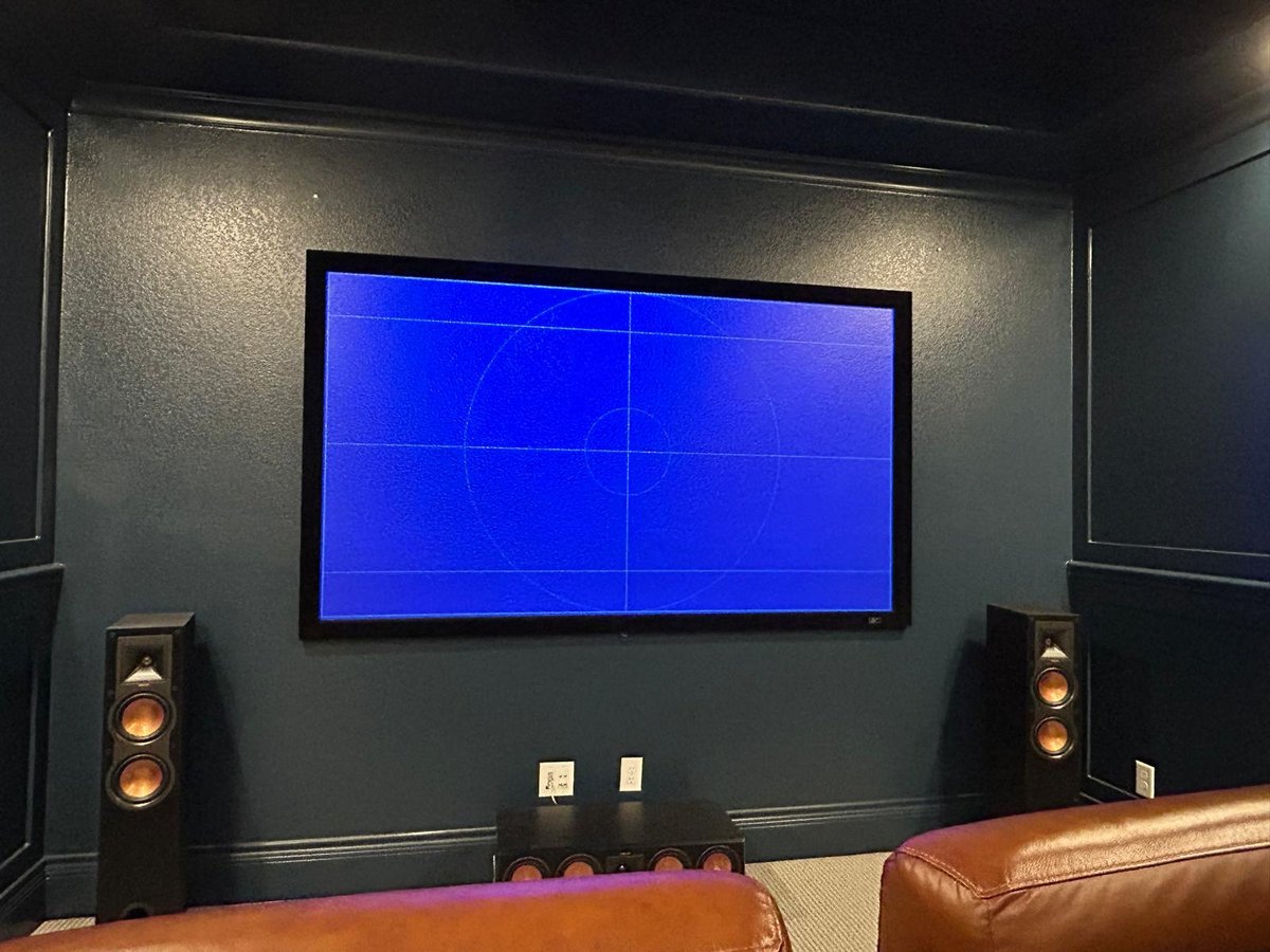 Home theater screen with tower speakers flanking the front — calibrated and ready
